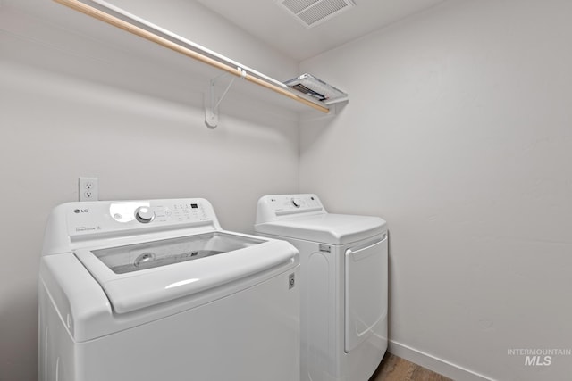 laundry room with dark hardwood / wood-style flooring and independent washer and dryer