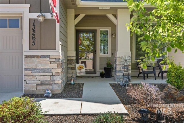 property entrance with a porch and stone siding
