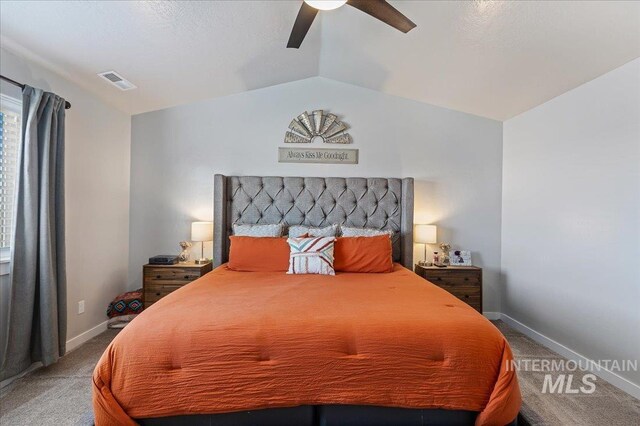 bedroom featuring light colored carpet, baseboards, vaulted ceiling, and visible vents