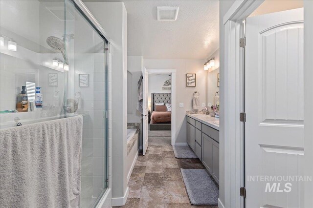 bathroom with stone finish flooring, visible vents, a stall shower, vanity, and ensuite bathroom