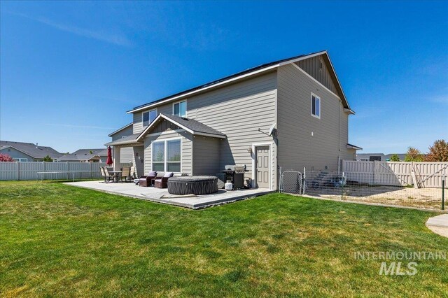 back of property with a fenced backyard, a gate, a patio, and a yard