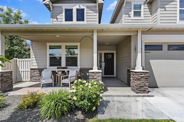 view of exterior entry featuring a porch and a garage