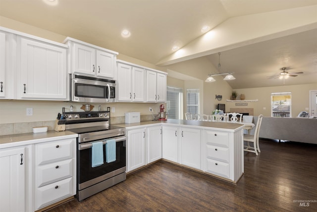 2493 S Skyview Dr, Nampa, ID 83686 - kitchen with stainless steel appliances, vaulted ceiling, open floor plan, a peninsula, and light countertops