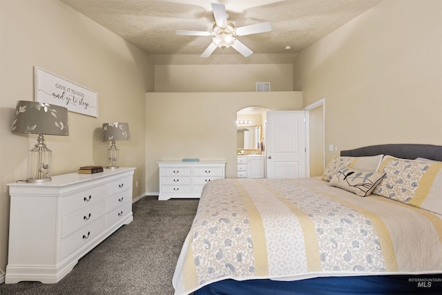 2493 S Skyview Dr, Nampa, ID 83686 - bedroom with dark colored carpet, arched walkways, ensuite bath, and a ceiling fan