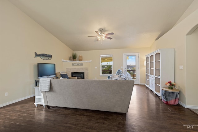 2493 S Skyview Dr, Nampa, ID 83686 - living area with ceiling fan, a tiled fireplace, dark wood-type flooring, vaulted ceiling, and arched walkways