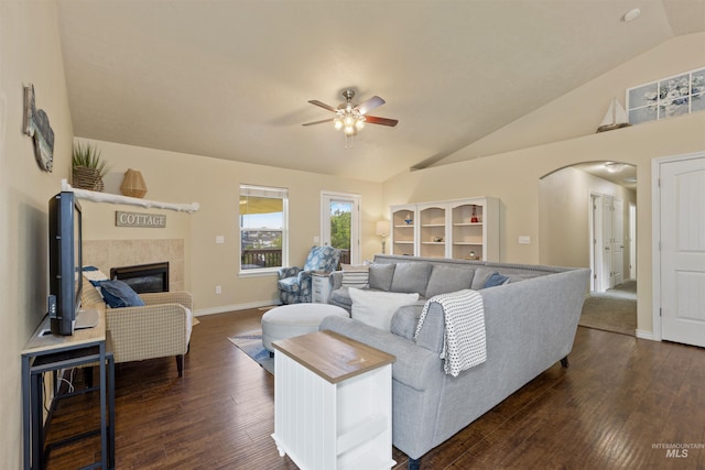 2493 S Skyview Dr, Nampa, ID 83686 - living room with lofted ceiling, arched walkways, ceiling fan, dark wood-type flooring, and a tile fireplace