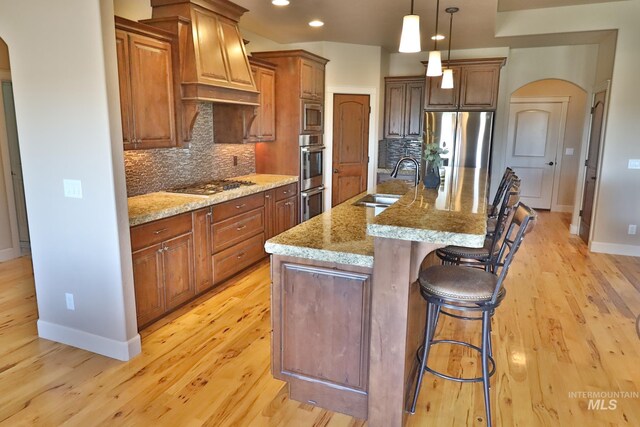 924 Main St S, Kimberly, ID 83341 - kitchen featuring stainless steel appliances, arched walkways, light wood-style floors, tasteful backsplash, and recessed lighting