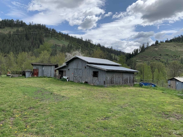 120 Three Bear Ln, Stites, ID 83552 - view of grassy yard featuring an outbuilding, a mountain view, a barn, and a view of trees