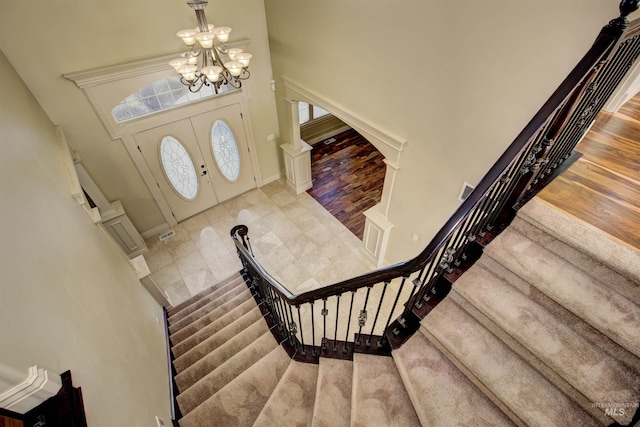 entryway featuring a towering ceiling and a chandelier