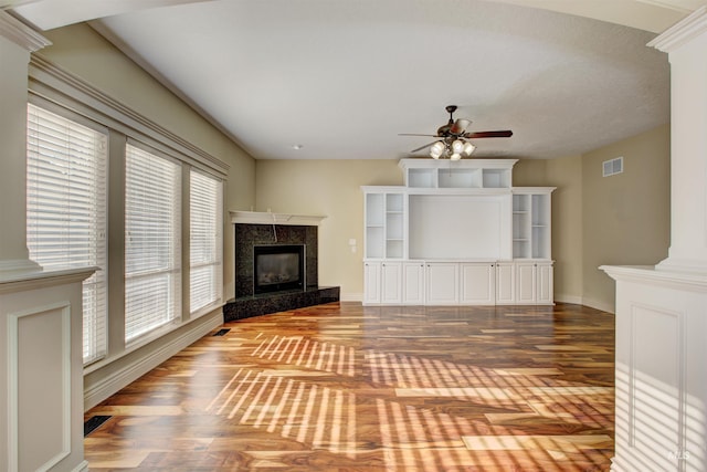 unfurnished living room featuring hardwood / wood-style flooring, a premium fireplace, and ceiling fan