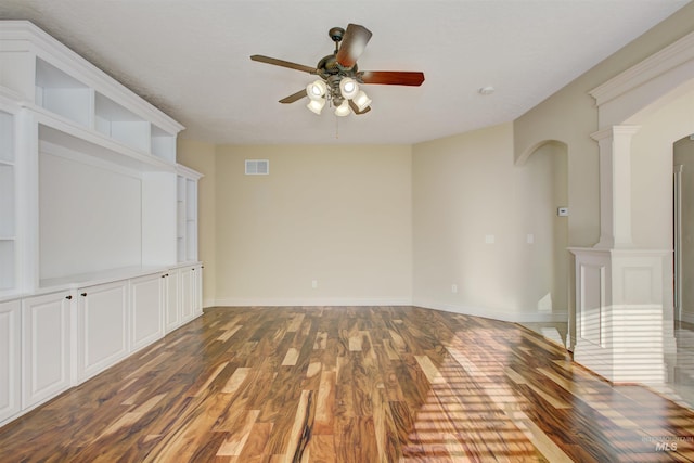 unfurnished room featuring ceiling fan, dark hardwood / wood-style flooring, and ornate columns