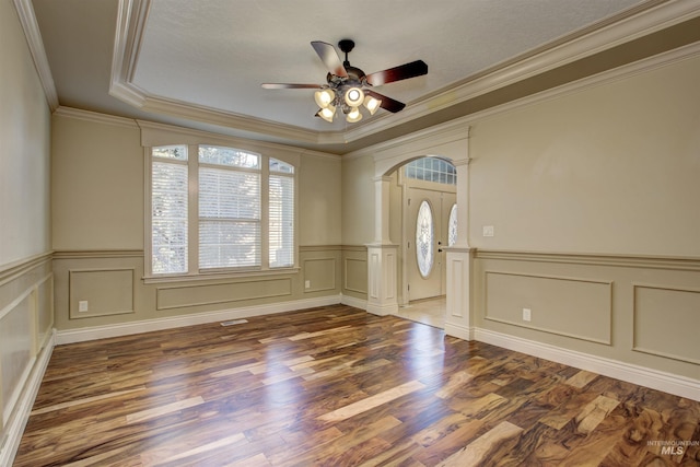 foyer with hardwood / wood-style flooring, a raised ceiling, ceiling fan, and crown molding