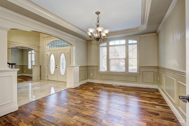 foyer featuring french doors, an inviting chandelier, ornamental molding, and a healthy amount of sunlight