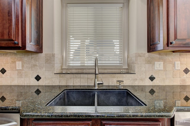 kitchen with sink, decorative backsplash, and dark stone counters