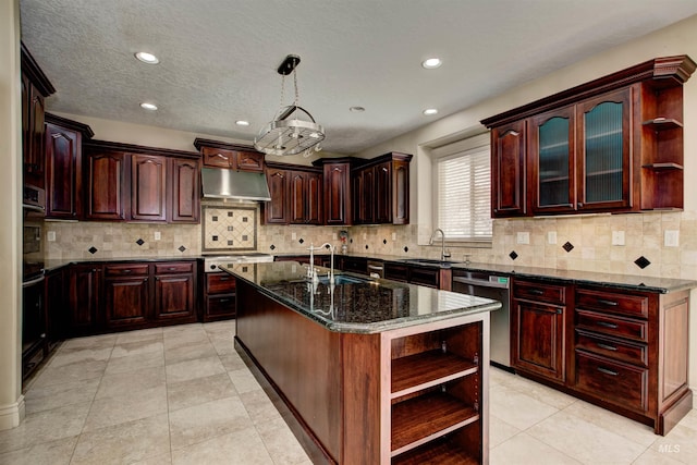 kitchen featuring pendant lighting, a center island with sink, dark stone counters, appliances with stainless steel finishes, and sink