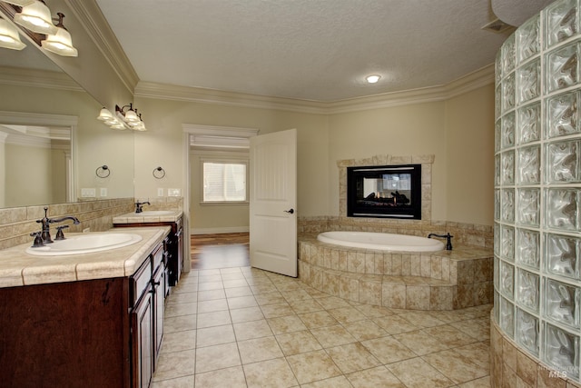 bathroom featuring a textured ceiling, tile patterned flooring, a multi sided fireplace, crown molding, and vanity