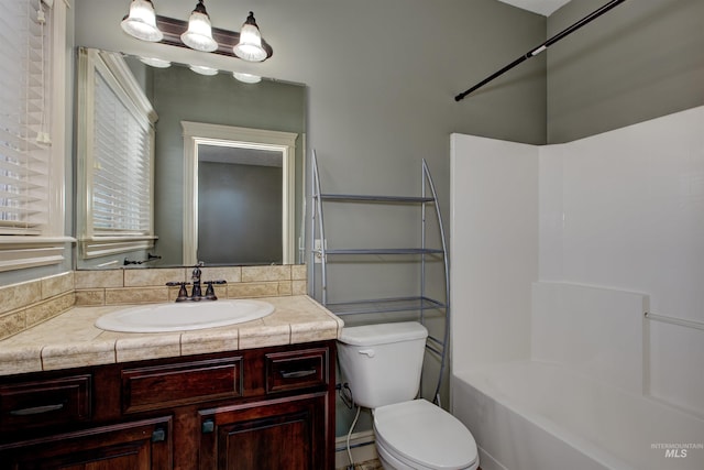 full bathroom with washtub / shower combination, baseboard heating, vanity, and toilet