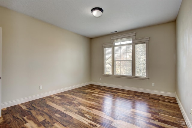 empty room featuring dark wood-type flooring