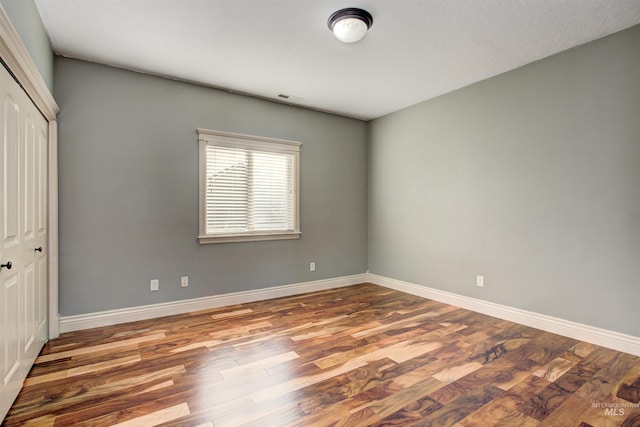 unfurnished bedroom with a closet and hardwood / wood-style flooring