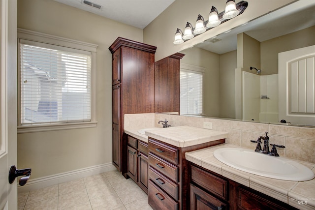 bathroom featuring tile patterned flooring, backsplash, and vanity