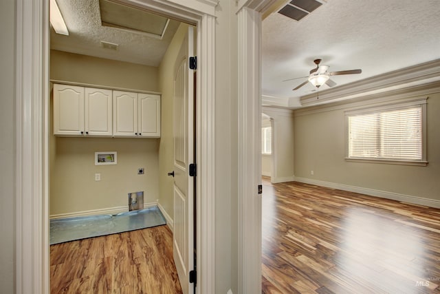 clothes washing area featuring cabinets, washer hookup, ornamental molding, electric dryer hookup, and a textured ceiling