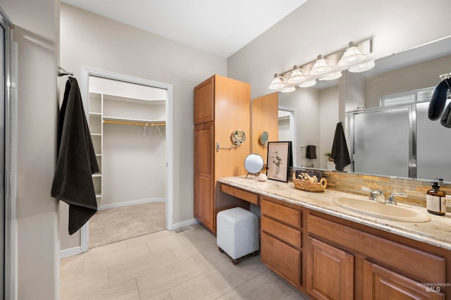 bathroom featuring vanity, tile patterned floors, decorative backsplash, and an enclosed shower