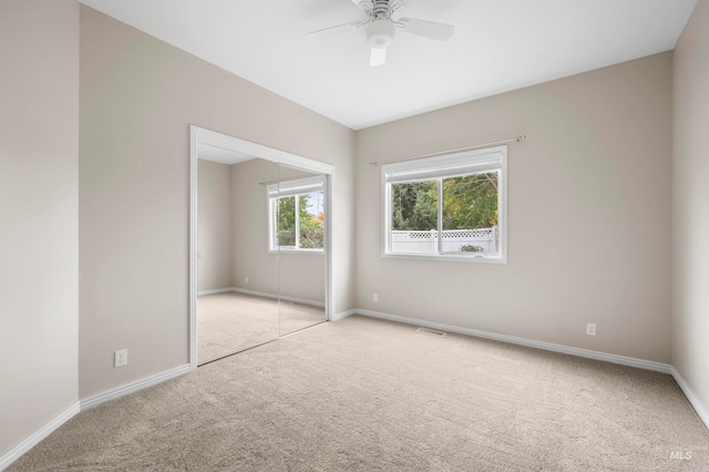 unfurnished bedroom with light carpet, a closet, and ceiling fan