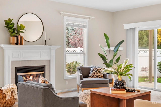 sitting room featuring carpet floors, a tile fireplace, and plenty of natural light