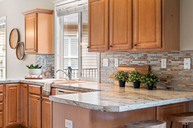 kitchen with a breakfast bar area, kitchen peninsula, and backsplash