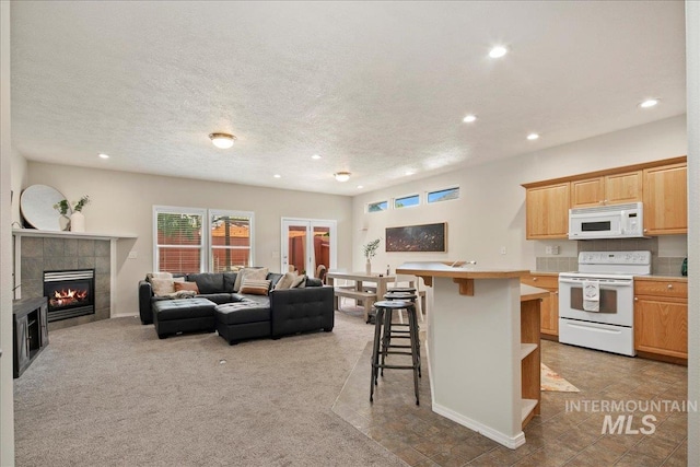 9425 W Java Ct, Boise, ID 83704 - living area with recessed lighting, a tiled fireplace, a textured ceiling, and light carpet