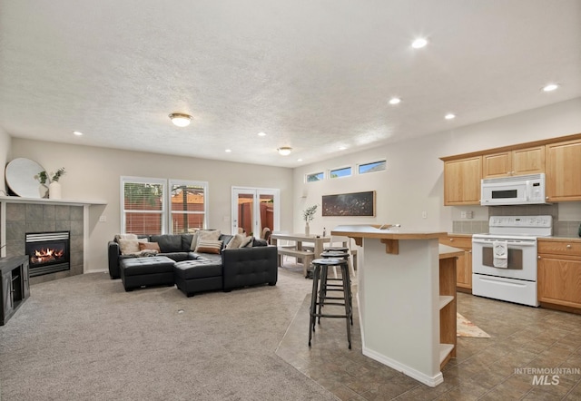 9425 W Java Ct, Boise, ID 83704 - living room featuring recessed lighting, a tiled fireplace, a textured ceiling, carpet flooring, and baseboards