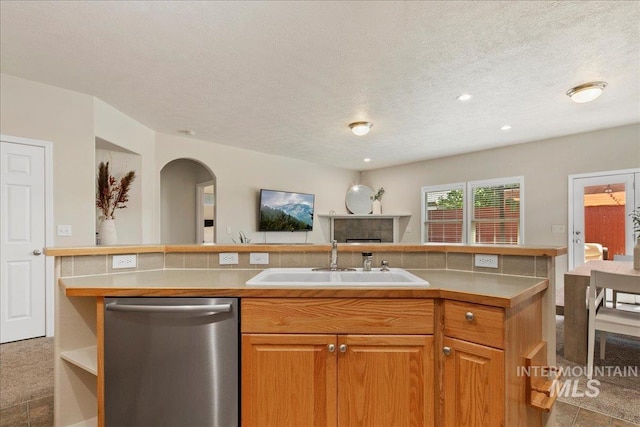 9425 W Java Ct, Boise, ID 83704 - kitchen with stainless steel dishwasher, a sink, a textured ceiling, arched walkways, and light countertops