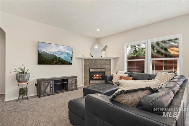 9425 W Java Ct, Boise, ID 83704 - living area with a tiled fireplace, carpet flooring, recessed lighting, baseboards, and arched walkways
