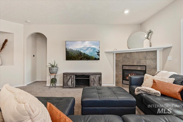 9425 W Java Ct, Boise, ID 83704 - carpeted living area featuring a tile fireplace, arched walkways, recessed lighting, and baseboards