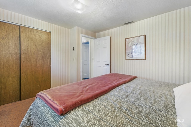 carpeted bedroom with wallpapered walls and visible vents