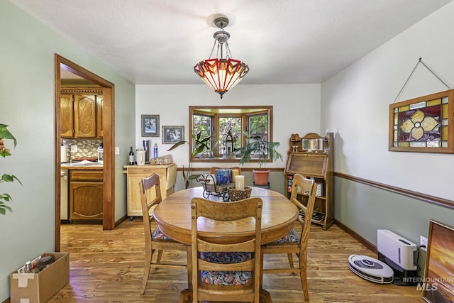 dining area with light wood-style floors and baseboards