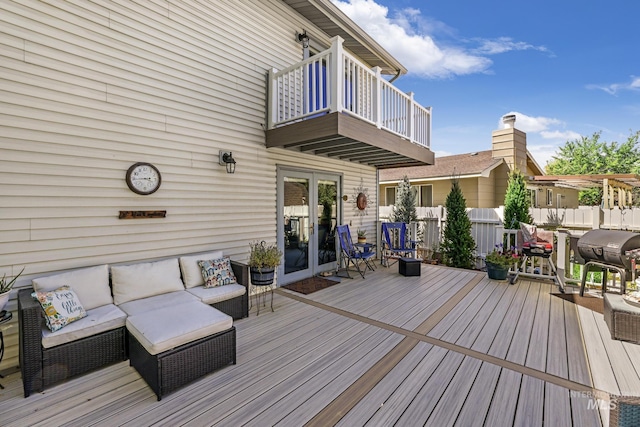 wooden terrace featuring area for grilling, fence, and an outdoor living space