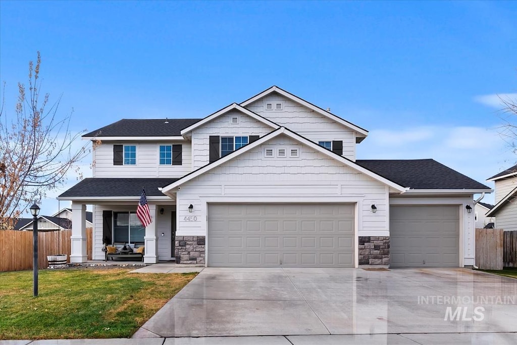 view of front of house with a front lawn, a porch, and a garage