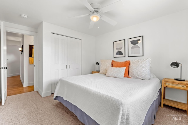 carpeted bedroom with a closet, ceiling fan, and baseboards