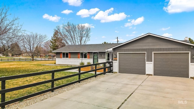 single story home featuring a front lawn, fence, concrete driveway, an attached garage, and brick siding