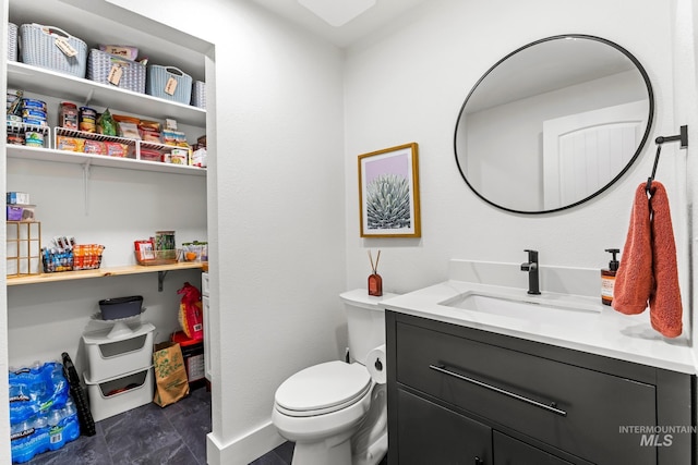 half bath with baseboards, toilet, and vanity