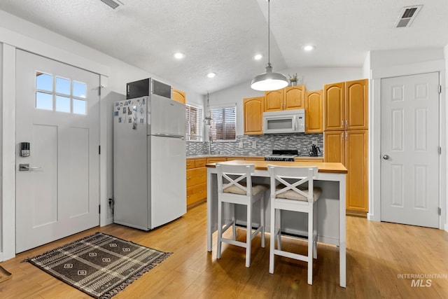 kitchen with light wood-style floors, white appliances, light countertops, and visible vents