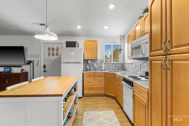 kitchen featuring white appliances, light wood-style flooring, a sink, wood counters, and tasteful backsplash