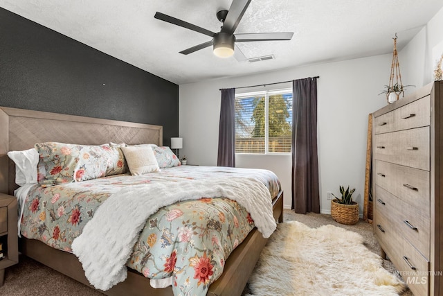 bedroom featuring baseboards, visible vents, ceiling fan, a textured ceiling, and light colored carpet