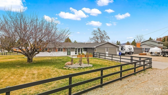 ranch-style house featuring a front lawn, fence, a garage, and driveway