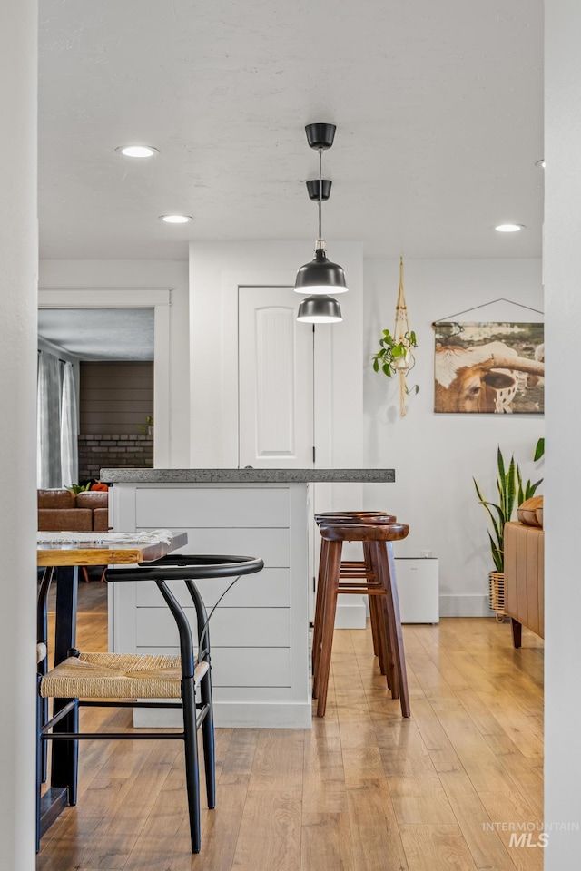 bar with decorative light fixtures, recessed lighting, and light wood finished floors