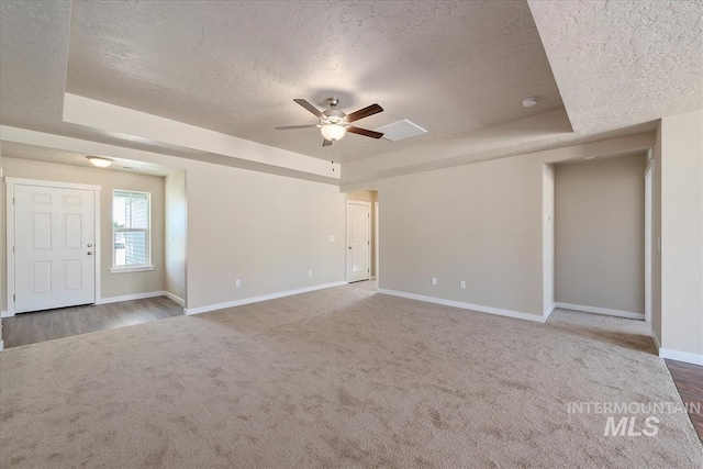 19144 Red Eagle Way, Caldwell, ID 83605 - unfurnished living room featuring a tray ceiling, baseboards, a textured ceiling, visible vents, and ceiling fan