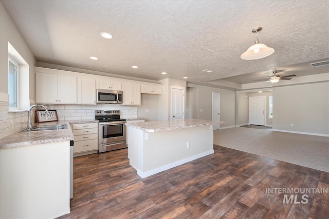 19144 Red Eagle Way, Caldwell, ID 83605 - kitchen with decorative backsplash, a sink, appliances with stainless steel finishes, and dark wood finished floors