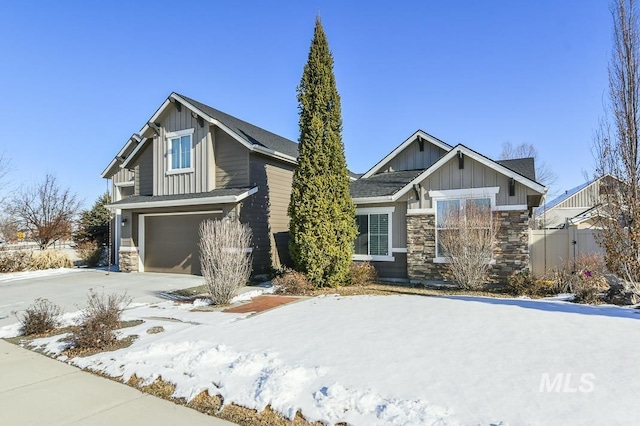 craftsman house with stone siding, board and batten siding, an attached garage, and fence