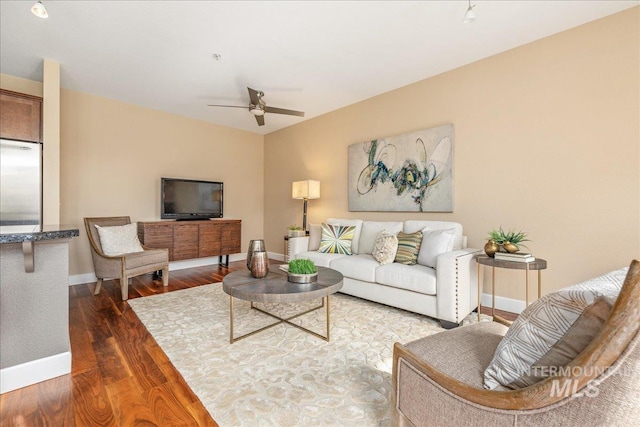 living area featuring ceiling fan, wood finished floors, and baseboards